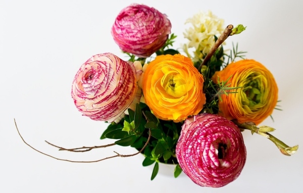 Букет разноцветных цветов лютика на сером фоне