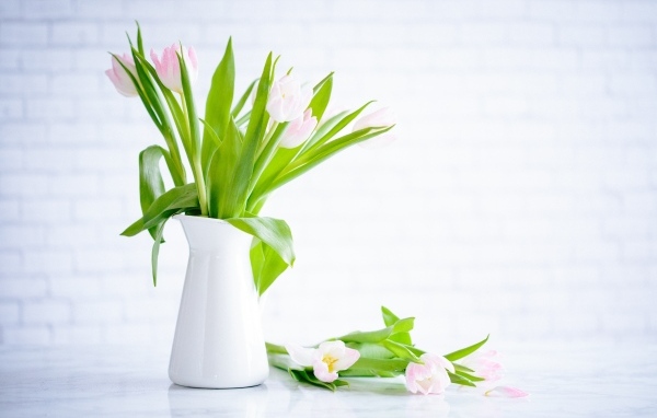 Букет розовых тюльпанов в белой вазе на столе