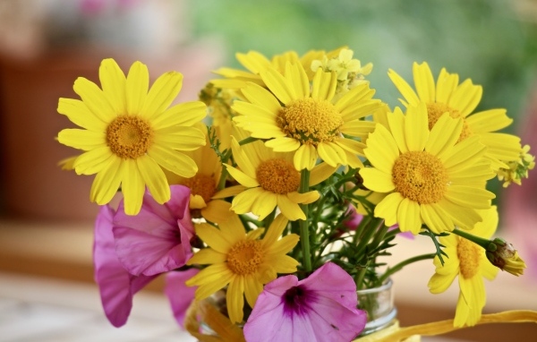 Букет желтых и розовых цветов в вазе на столе