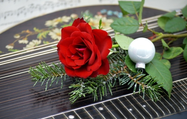 Красная роза с шариком и еловой веткой