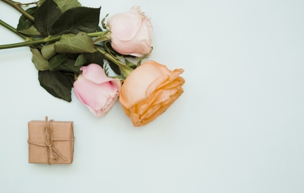 Три розы и подарок на сером фоне
