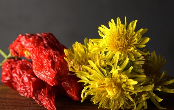Желтые одуванчики с красным перцем на столе