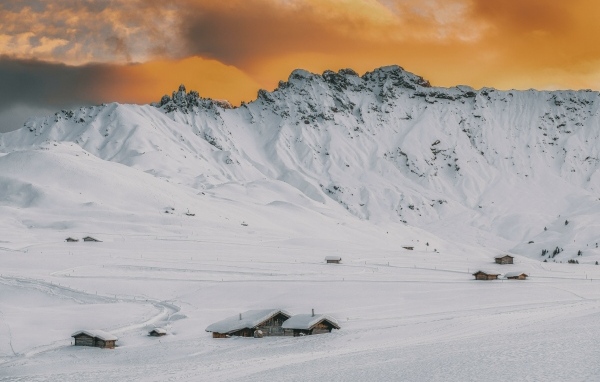 Красивая заснеженная гора под оранжевым небом