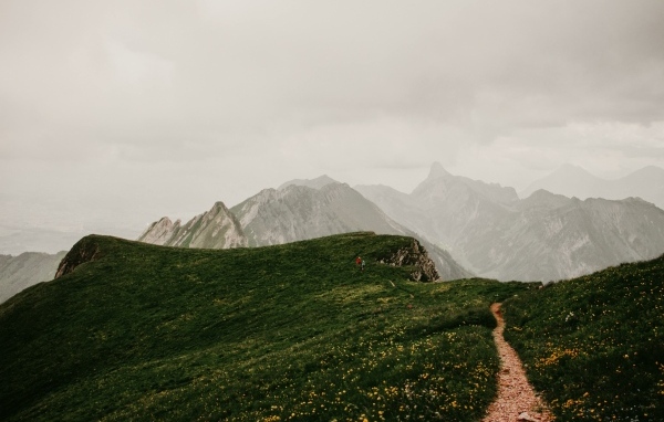 Тропа в покрытых зеленой травой горах