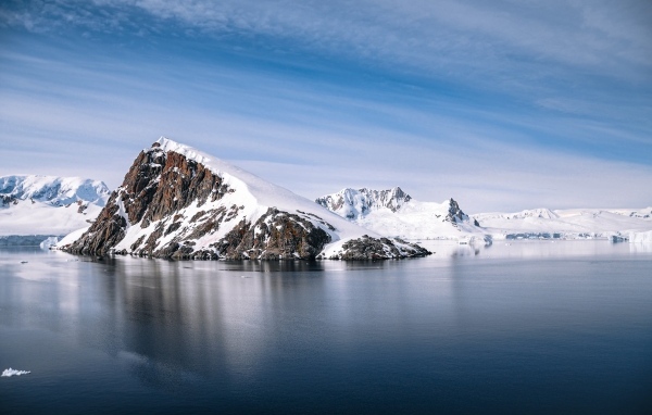 Скала в море покрыта снегом