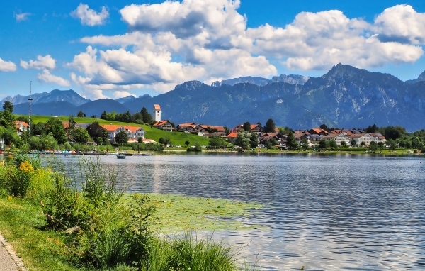 Красивый вид на озеро и горы под голубым небом с белыми облаками