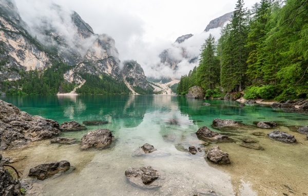 Камни лежат в воде озера в холодных горах