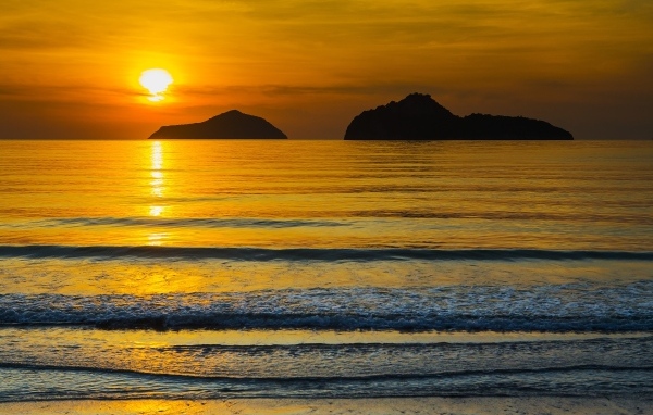 Красивый закат над спокойным морем летом