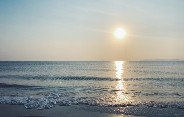 Яркое солнце над спокойным морем летом