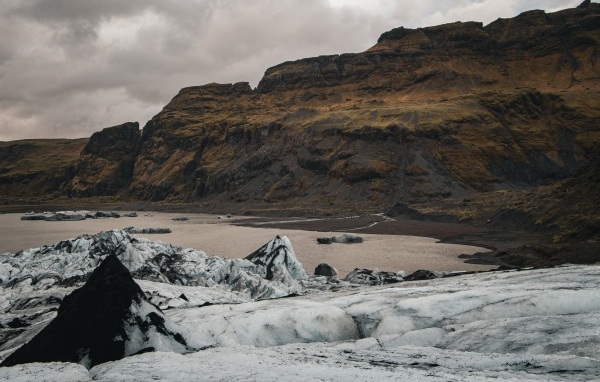 Холодный грязный снег на берегу моря у гор 