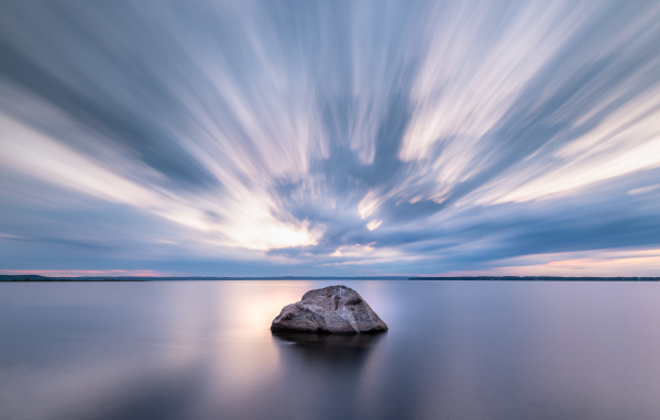Большой камень в воде под красивым небом