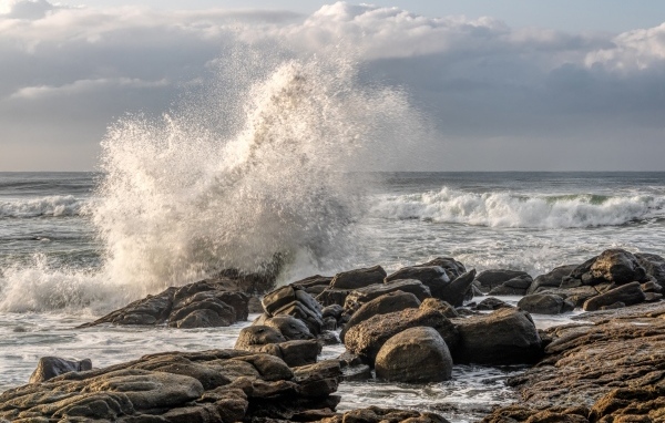Морские волны бьются о камни на берегу