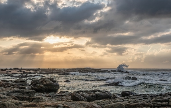 Лучи солнца пробиваются сквозь тучи над морем