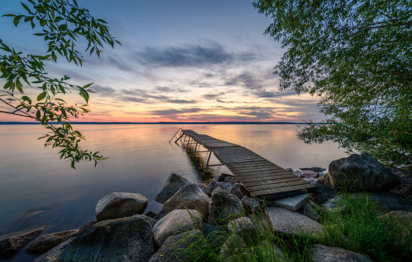 Старый деревянный пирс у озера на закате