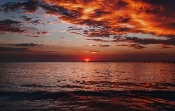 Красные облака в небе над морем на закате