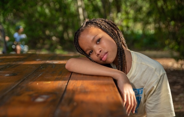 Красивая темнокожая девочка с косичками на голове 