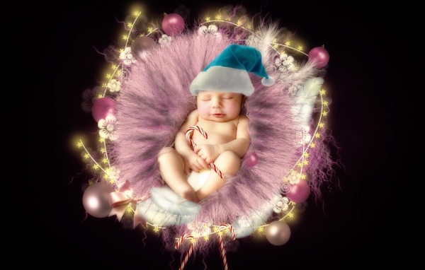 Красивый новорожденный ребенок в колыбели на черном фоне