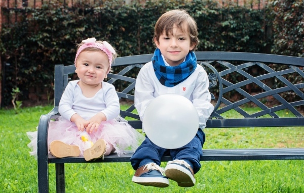 Мальчик и девочка сидят на лавке в парке