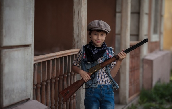 Мальчик охотник с ружьем в руках