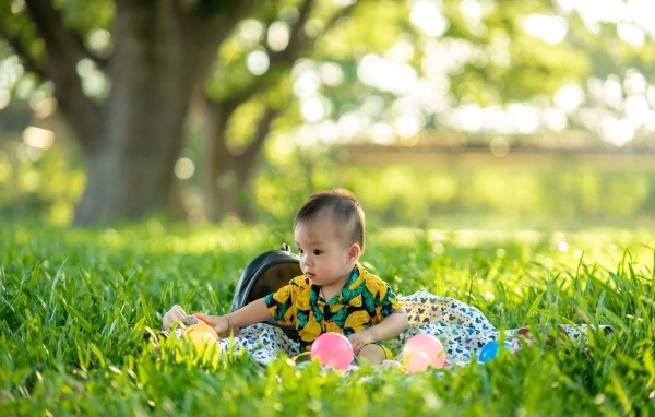 Милый маленький ребенок сидит на траве