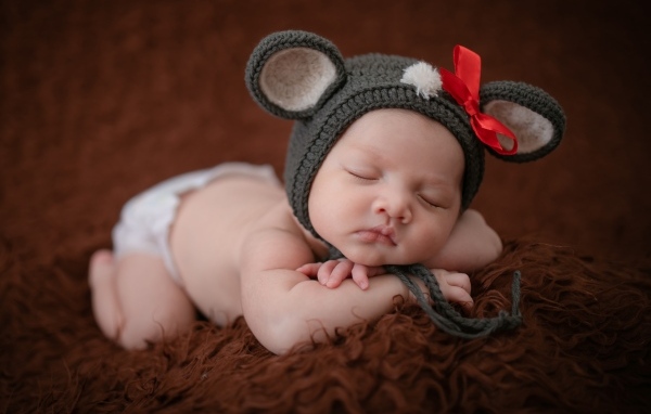 Смешная шапка на голове спящей малышки