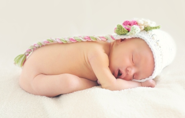 Нежный спящий ребенок в вязаной шапке 