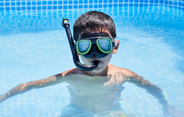 Маленький мальчик в маске в бассейне