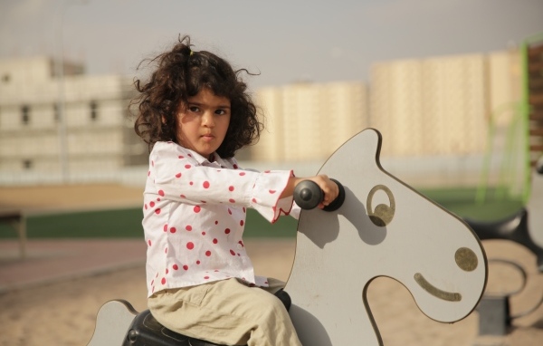 Маленькая девочка на деревянной лошади