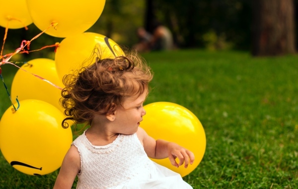 Маленькая девочка с желтыми шариками