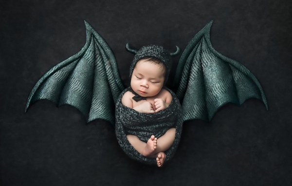 Маленький спящий ребенок с крыльями на Хэллоуин