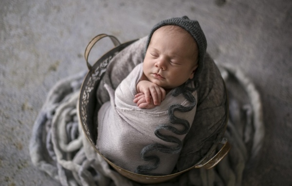 Маленький спящий новорожденный малыш в корзине