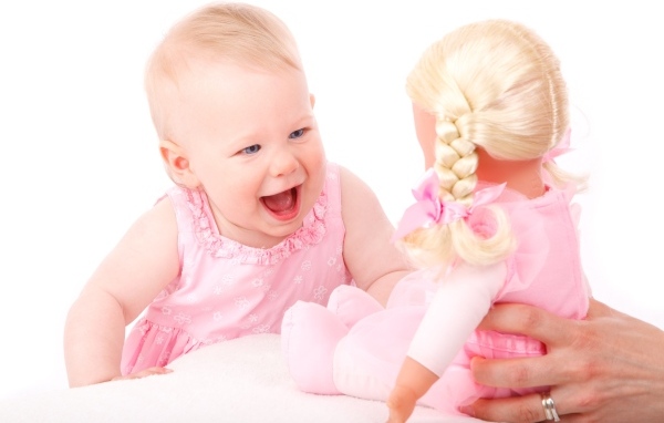 Маленькая улыбающаяся девочка с куклой