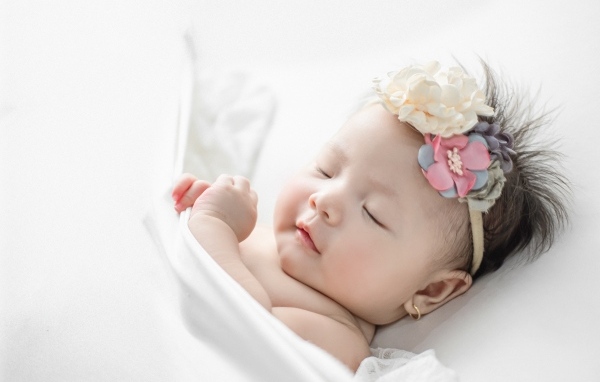 Новорожденная девочка с повязкой на голове