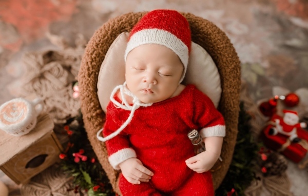 Новорожденный малыш в красном вязаном костюме