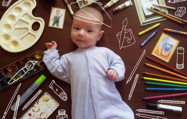 Новорожденный ребенок с канцелярскими предметами