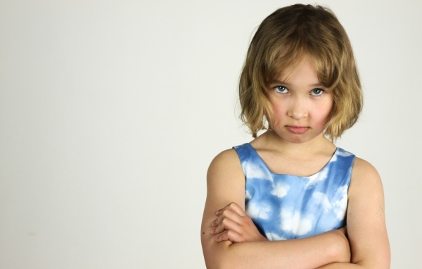 Серьезная девочка на сером фоне