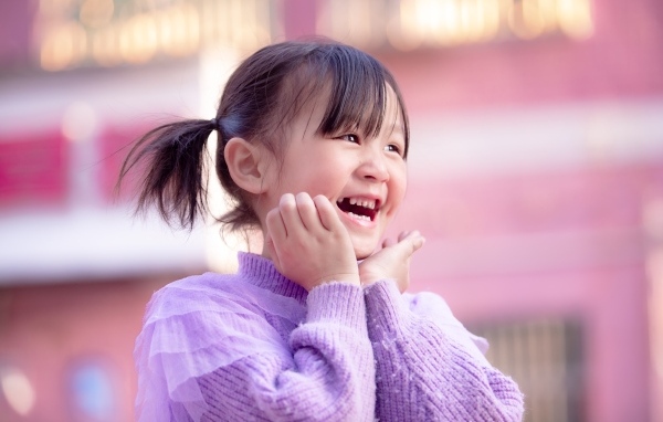 Улыбающаяся маленькая девочка азиатка в свитере