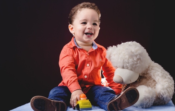 Улыбающийся мальчик с игрушечным медведем