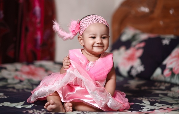 Улыбающаяся девочка в красивом розовом платье