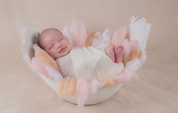 Улыбающийся спящий новорожденный малыш