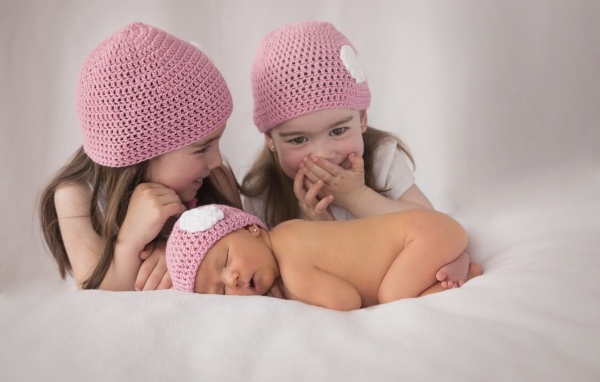 Три маленькие девочки в вязаных шапках