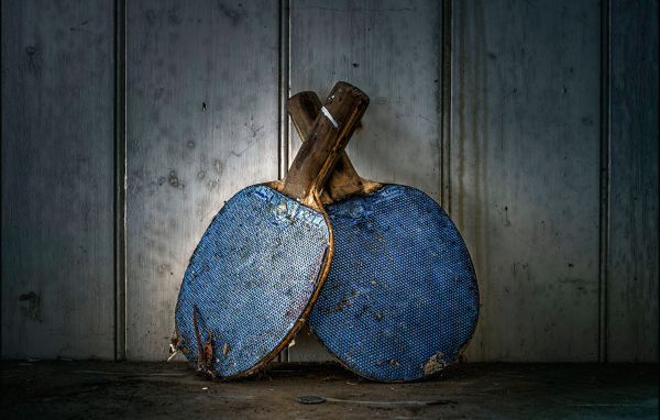 Две старые ракетки для настольного тенниса у стены