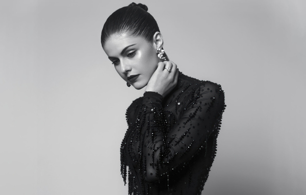 Актриса Александра Даддарио в черном платье на сером фоне