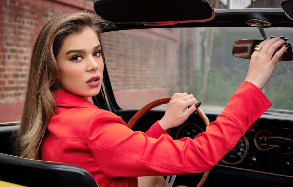 Актриса Хейли Стейнфилд в красной куртке в машине