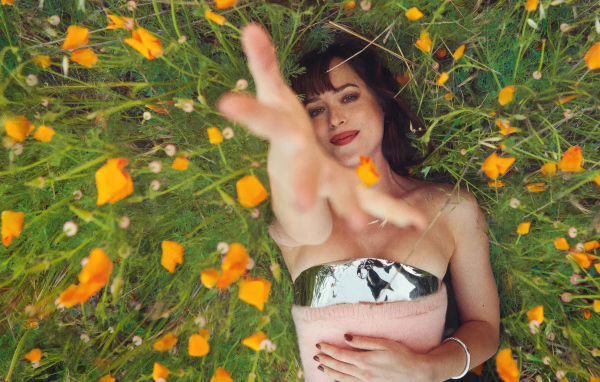 Американская актриса Дакота Джонсон лежит на траве с цветами