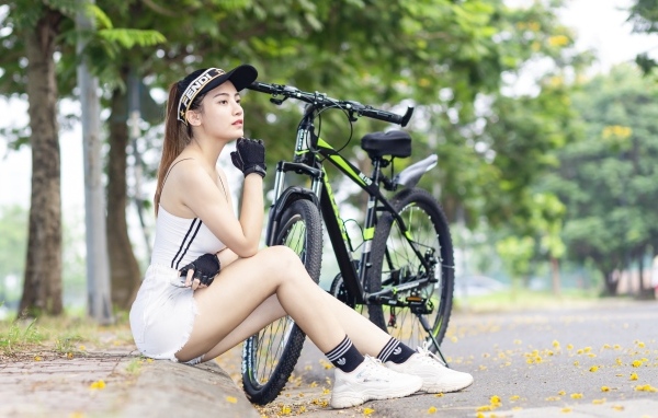 Спортивная девушка азиатка с велосипедом