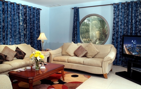 Синие шторы в гостиной с двумя диванами
