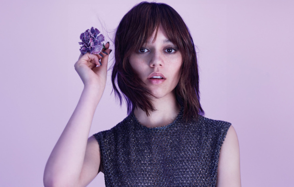 Милая молодая девушка актриса Дженна Ортега с цветком в руках