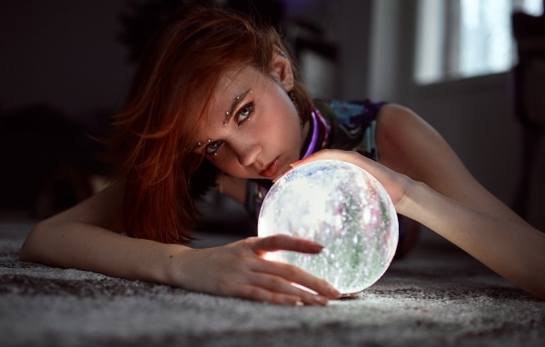 Девушка с пирсингом держит волшебный шар