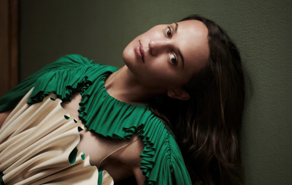 Длинноволосая актриса Алисия Викандер у стены